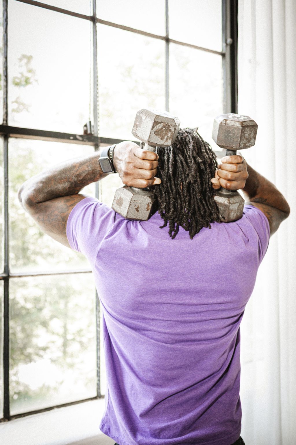 Coach Jamal Powers pressing dumbbells overhead