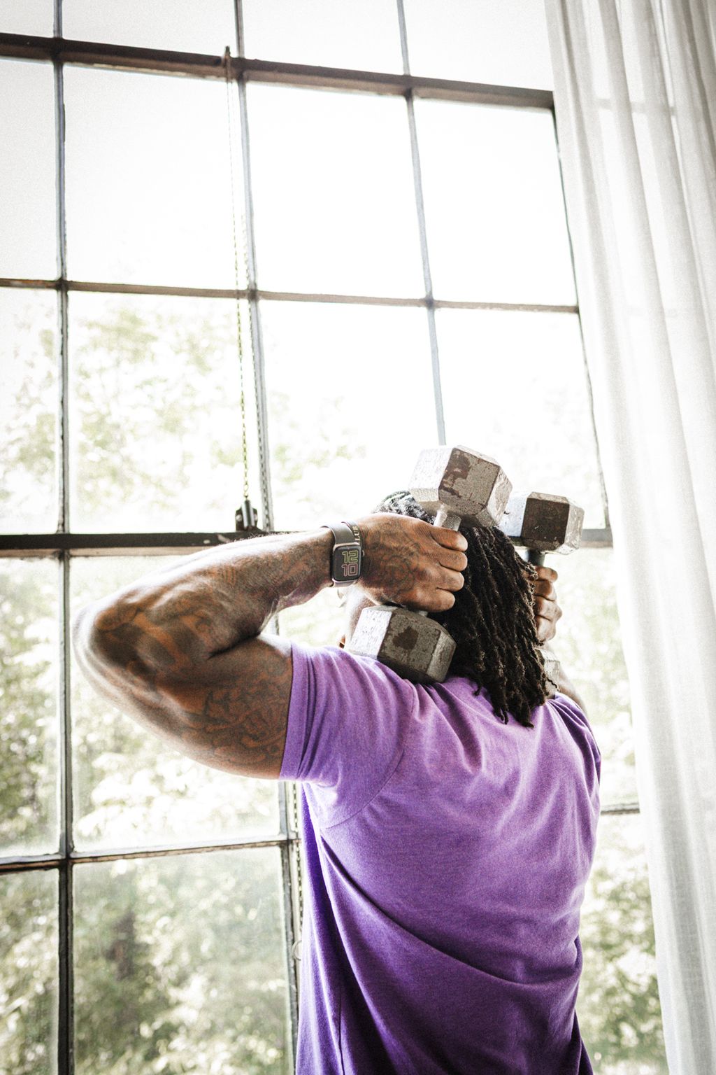 Coach Jamal pressing a dumbbell overhead