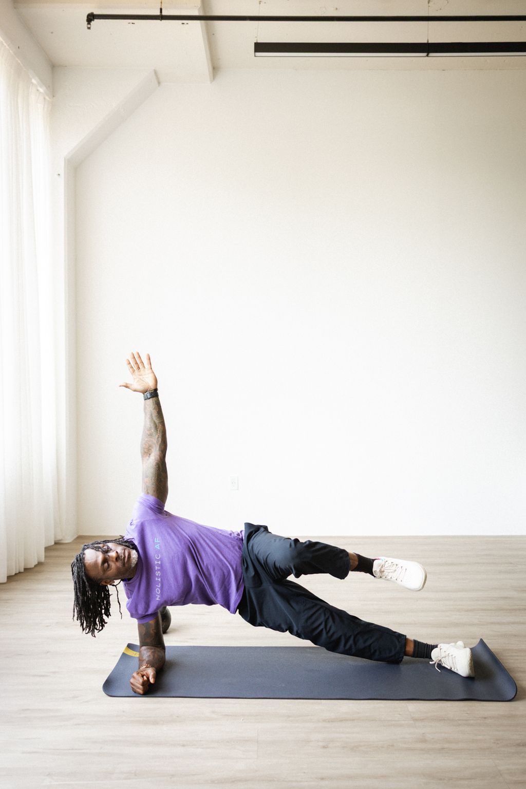 Coach Jamal holding a side plank on a mat