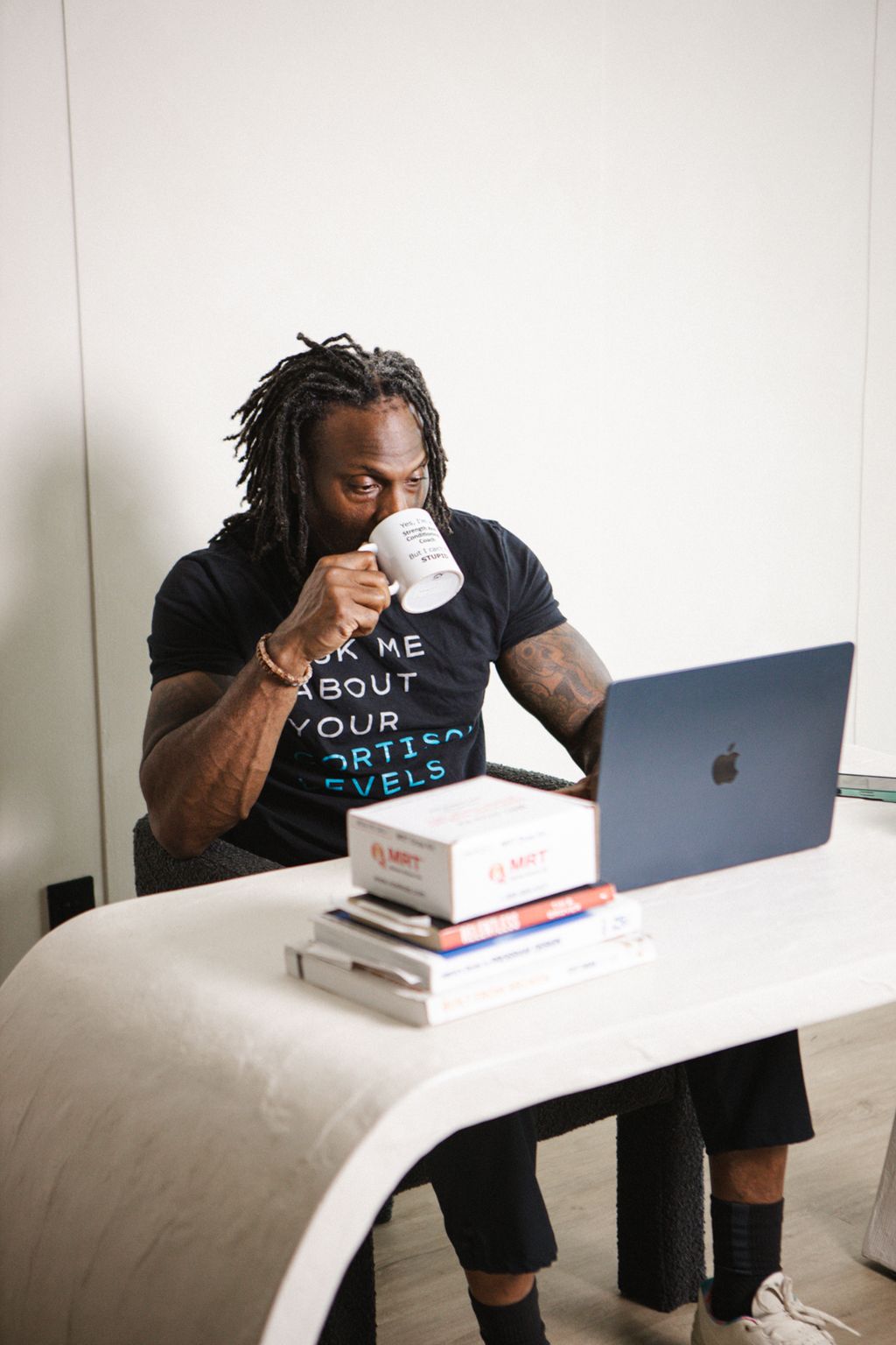 Coach Jamal with coffee at his laptop