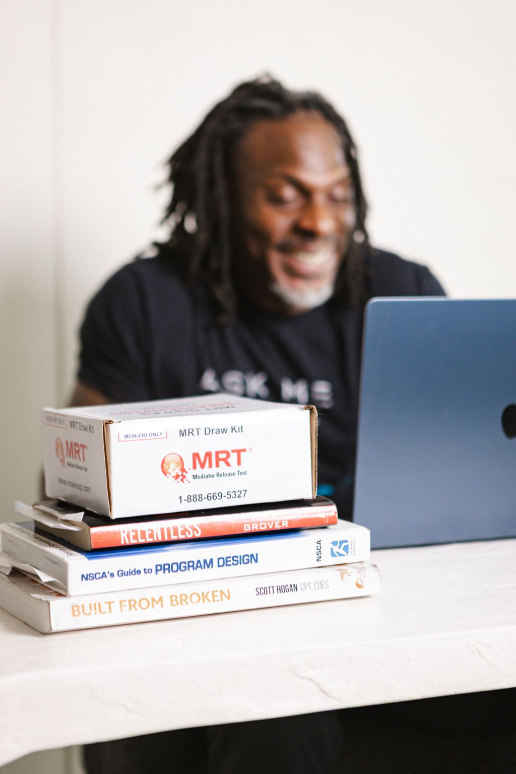 Coach Jamal laughing at his laptop next to lab kits